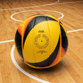 A yellow, black, and orange soccer ball with FIVB branding rests on a wooden indoor court with white boundary lines.